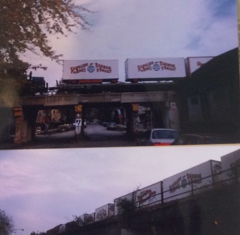 Train cars with the Ringling Bros. Barnum & Bailey Circus logo ride across a bridge.