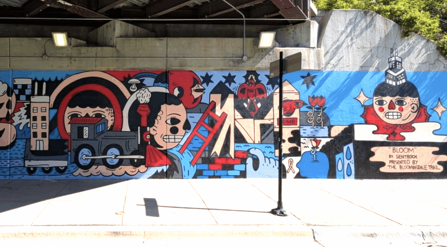 Colorful, illustrated mural under a bridge