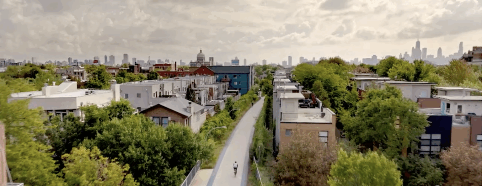 Aerial view of trail with biker and city in background